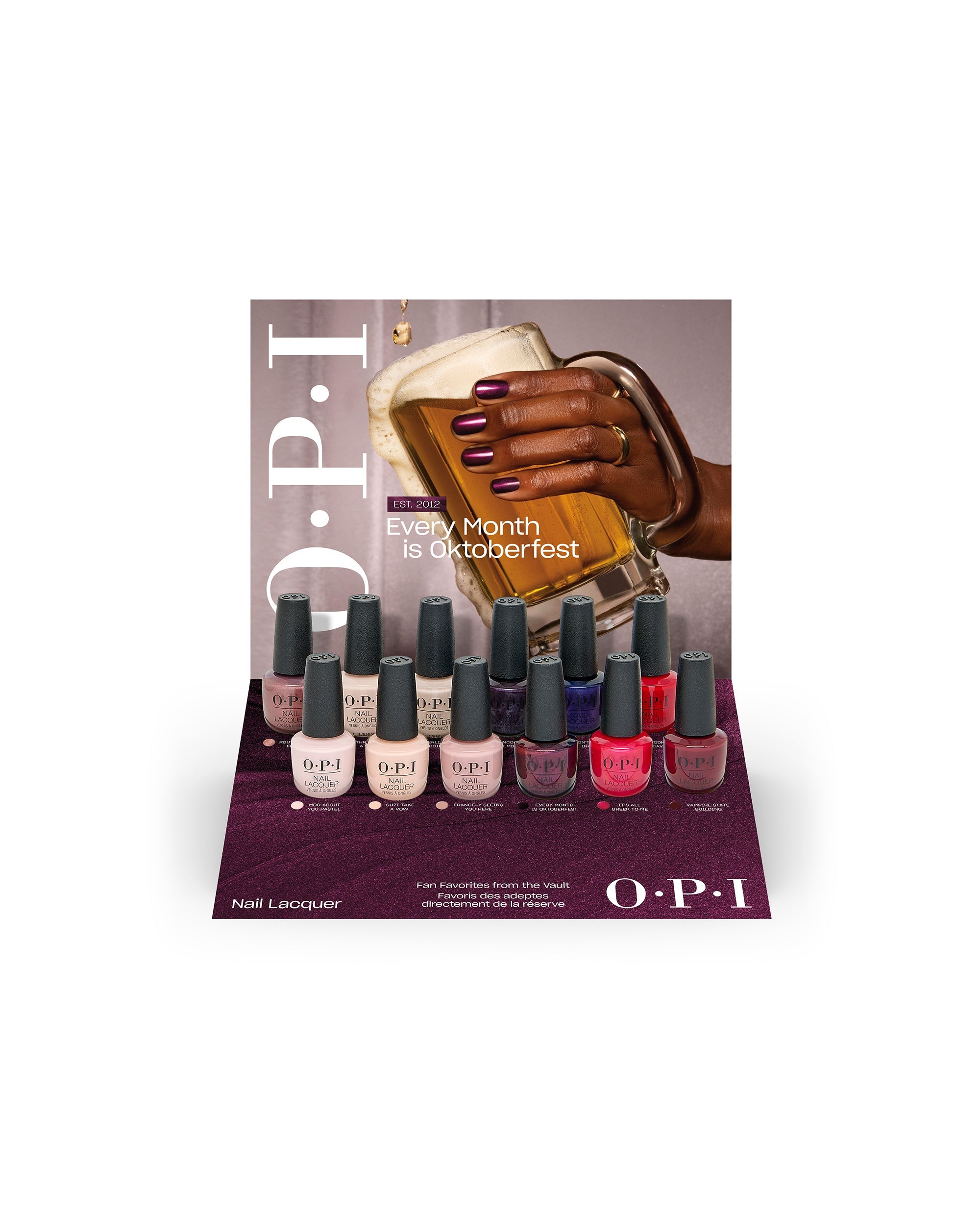 OPI Fall ’26 Nail Lacquer 12PC Vac Tray Display showcases 12 fall nail colors in a burgundy retail tray with an Oktoberfest-themed backdrop, featuring nude, pink, plum, red, and berry shades.