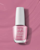 OPI Nature Strong Vegan Nail Lacquer in Knowledge is Flower, a soft rosy pink polish in a glass bottle with white cap, standing upright on a matching pink background, ideal as a clean beauty OPI nail polish gift set.