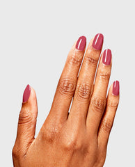 Hand with neatly manicured nails painted in a glossy mauve shade, showcasing the OPI Dry and Dash RapiDry nail polish gift set finish against a clean light gray background.