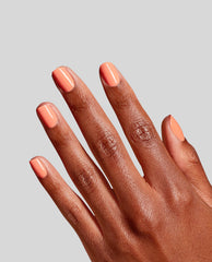 OPI RapiDry Within Peach nail polish coats short square nails in a glossy peach shade on a hand against a light gray studio background, showcasing a trending manicure color.