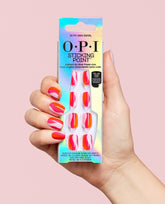Hand holding OPI Sticking Point In My Own Swirl press-on nails in iridescent packaging, with matching pink, orange, and pale pink swirl nail art on a soft pink background.