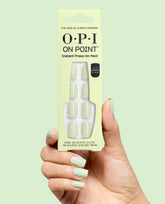 OPI On Point The Pass is Always Greener press-on nails in pale mint green, held in a hand with matching glossy manicure against a soft green background.