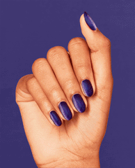 Hand displays short oval nails painted with Abstract After Dark OPI nail polish, a deep shimmering indigo nail lacquer, held against a matching purple background to showcase the rich, glossy nighttime hue.