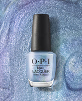 OPI nail polish Angels Flight to Starry Nights nail lacquer bottle standing upright, showcasing its iridescent icy blue shimmer shade against a close-up background of the same sparkling, glittery polish.