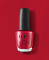 OPI nail polish bottle in the shade Art Walk in Suzi's Shoes, a vibrant classic red nail lacquer with a black textured cap, standing upright against a matching glossy red background for a bold manicure look.