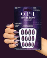 Hand holds OPI xPRESS/ON Aura After Dark press-on nails in a dark purple magnetic shimmer, with matching manicure and packaging for gel-like fall nail colors.