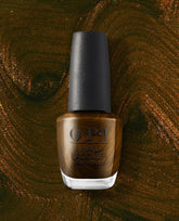 OPI nail polish bottle of Band Tease nail lacquer standing upright, showcasing a rich brown shade with golden shimmer, set against a swirling metallic bronze and green background that matches the polish color.