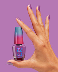Hand with glossy purple almond nails holds OPI RapiDry Bright Back at It nail polish bottle against a lavender background, showcasing quick-dry fall nail colors.