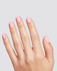 Hand showing short, neatly filed nails painted with BubbleYUM pastel pink at-home gel nail polish, glossy and even, against a light gray background, ideal for marketing an OPI-style nail polish gift set in the US.