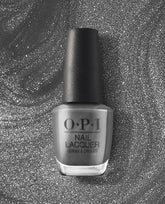 OPI nail polish bottle of Clean Slate nail lacquer standing upright, showcasing a sleek medium gray shade with a black cap against a swirling silver glitter background, highlighting the modern, neutral color for manicures and pedicures.