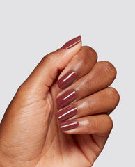 Hand modeling glossy mauve-brown Como Se Dice Gel-ous? at-home gel nail polish by OPI, showing rounded fall nail colors on a clean light gray background.