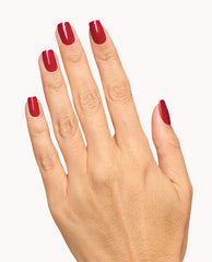Hand displays glossy deep red manicure with OPI Infinite Shine Deer Valley Spice, a rich shade for fall nail colors, on a clean white background.