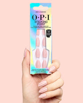 Hand holds OPI Sticking Point Drop a Pinstripe instant no-glue press-ons in an iridescent box, showing pink pinstripe nails, a chic option among OPI fall nail colors.