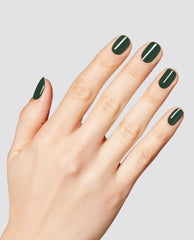 Hand displays glossy deep forest green nails in OPI Fir Surely Fast RapiDry polish, with a smooth manicure finish against a light gray studio background.