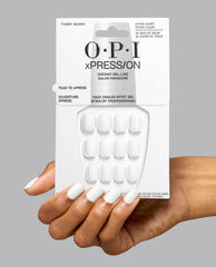 Hand holding OPI xPRESS/ON Funny Bunny extra short press-on nails, a soft white pick among fall nail colors, with gel-like packaging and matching glossy manicure on gray.