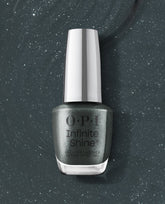 OPI nail polish Infinite Shine Get in Platform-ation bottle standing upright, showcasing a deep slate-gray gel-like lacquer packed with fine silver shimmer against a matching sparkling polish smear background.