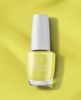 OPI Nature Strong Vegan Nail Lacquer in Give Me Some Suga Cane standing upright, white cap and clear bottle revealing a pale lime-green hue, casting a soft shadow on a matching glossy background—green nail polish ideal for spring nail colors.