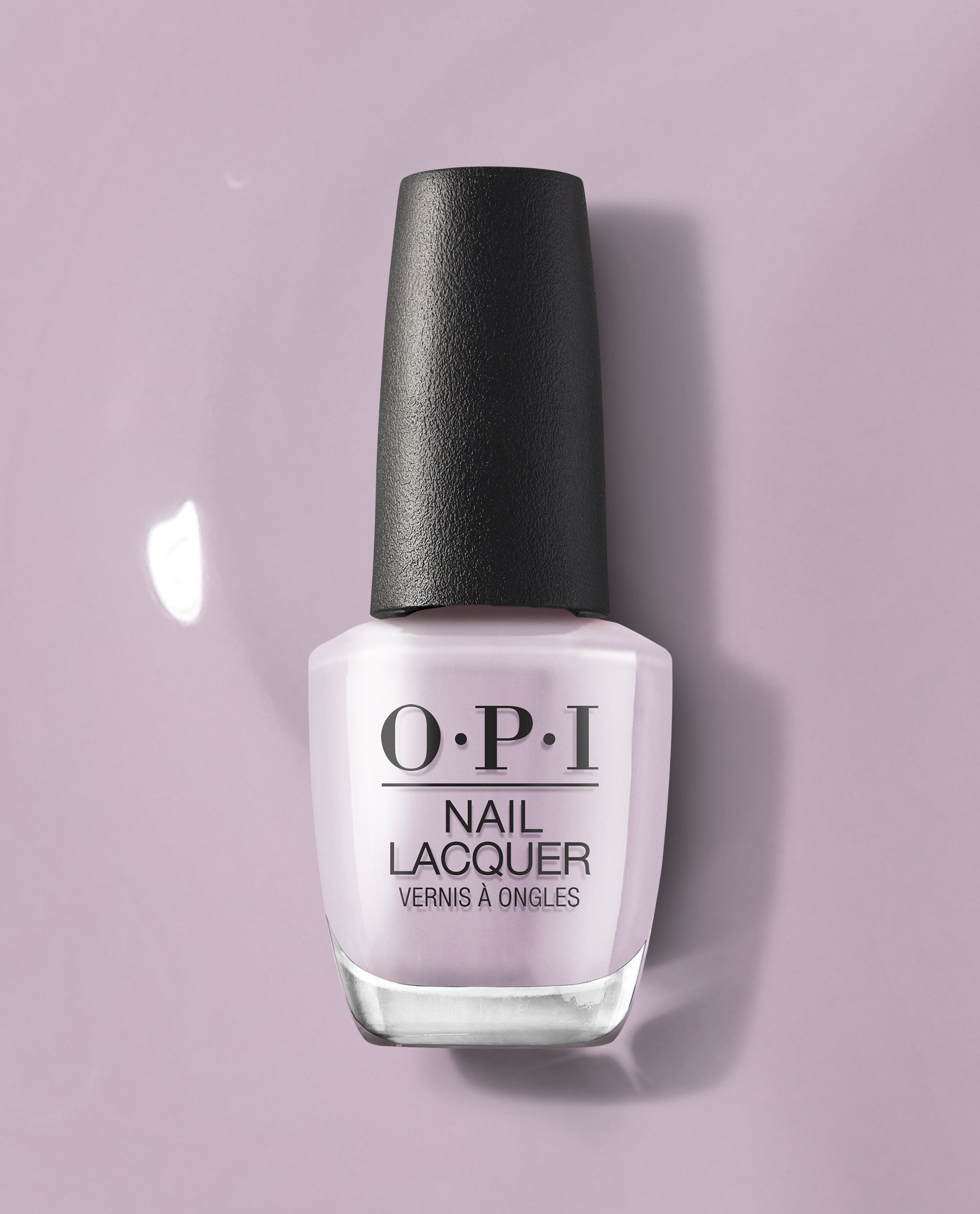 OPI nail polish bottle in the Graffiti Sweetie shade standing upright, showcasing pale lavender nail lacquer with a black cap against a matching soft purple background, highlighting the glossy pastel color for manicures and pedicures.