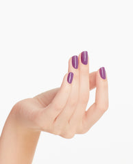 Hand with neatly manicured nails showcases OPI nail polish in Grandma Kissed a Gaucho, a glossy medium purple nail lacquer, against a clean white background for a modern, salon-quality look.