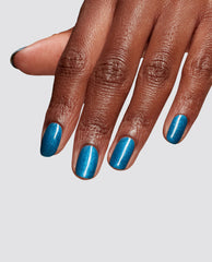 Hand displays glossy teal-blue shimmer nails with I Sea You at-home gel nail polish, an OPI trending shade, against a clean light gray studio background.