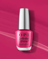OPI Infinite Shine Koala Bear-y bright pink gel-like nail lacquer bottle stands on a matching glossy pink background, a bold choice for fall nail colors.