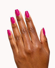Hand modeling glossy magenta OPI Infinite Shine nail polish in Koala Bear-y, a bold pink shade for fall nail colors, on short square nails against a clean white background.
