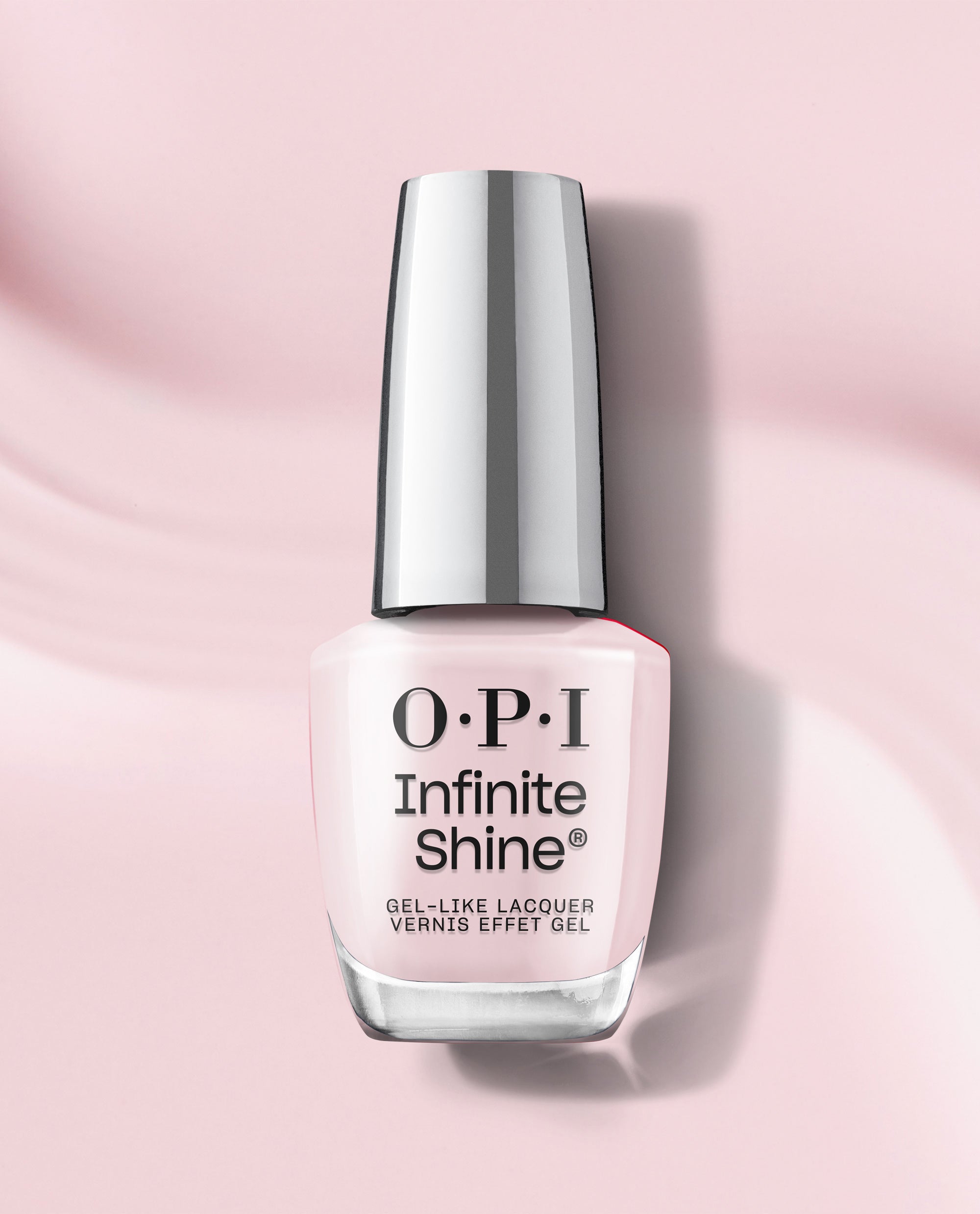 OPI Infinite Shine Lavender Bath pale pink gel-like lacquer bottle stands upright on a soft pink background with a reflective silver cap and subtle shadow.