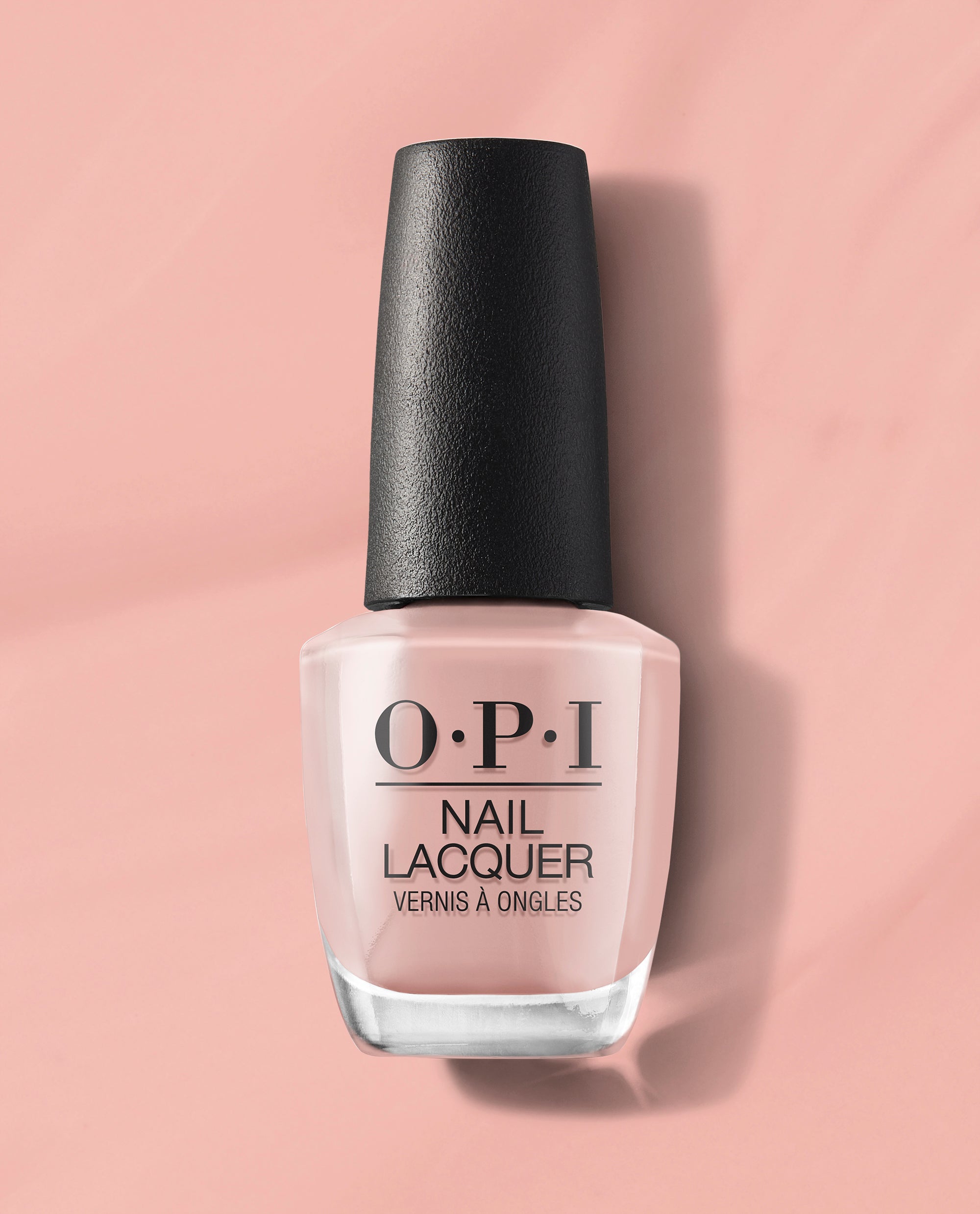OPI nail polish bottle of Machu Peach-u nail lacquer standing upright, showcasing its soft peachy pink shade against a matching blush background, highlighting the glossy finish and black textured cap for a modern, feminine look.