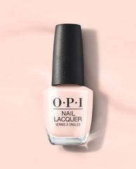 OPI Mod About You Pastel nail lacquer bottle in soft pale pink with a black textured cap, standing on a peach-pink background as a subtle choice for fall nail colors.