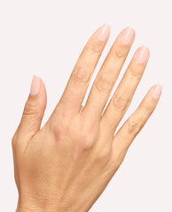 Hand displays glossy pale pink OPI Mod About You Pastel Nail Lacquer on short rounded-square nails against a clean light background, a soft pick for fall nail colors.