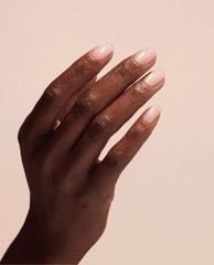Hand with short, glossy nude-pink nails flexing to show the smooth, strengthened finish created by OPI Nail Envy Bubble Bath Nail Strengthener treatment, ideal as a nail polish gift set option against a soft blush background.