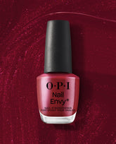 OPI Nail Envy Tough Luv Nail Strengthener bottle stands upright with a black cap and shimmery berry-red formula against a sparkling deep red backdrop, ideal for fall nail colors.
