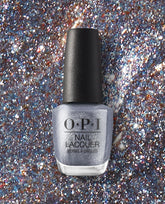 OPI Nails the Runway OPI nail polish bottle standing upright, showcasing silver glitter nail lacquer against a sparkling multicolor glitter background, emphasizing the shimmery, high-shine finish of this OPI nail lacquer shade.