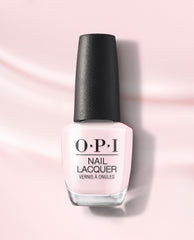 OPI OPI’m a Bubble Bunny nail lacquer bottle in a soft pale pink shade with a textured black cap, standing on a light pink background with subtle shadows.