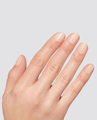 Hand displaying neatly manicured nails painted in Pilates Princess, a pale nude at-home gel nail polish from OPI, shown against a light gray background as a subtle, glossy shade option for an OPI nail polish gift set