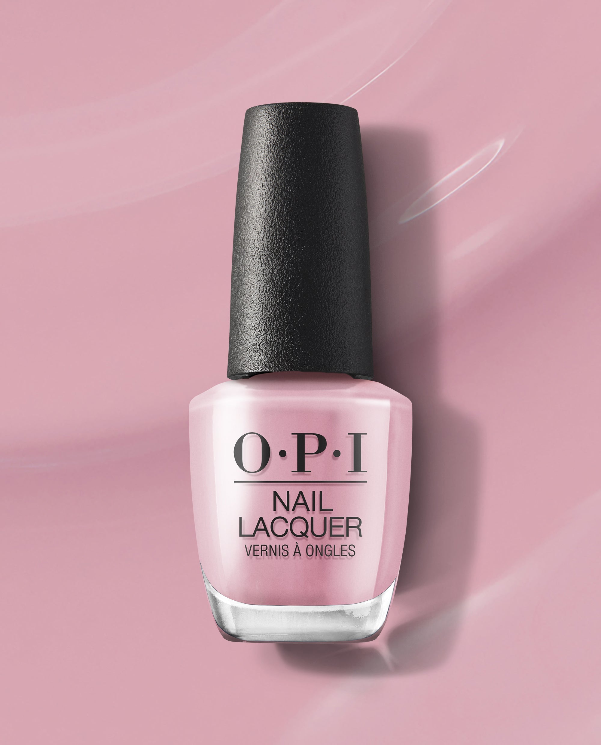 OPI nail polish bottle of (P)Ink on Canvas nail lacquer standing upright, showcasing its soft pastel pink shade with black cap against a glossy pink painted background, highlighting the salon-quality manicure color for US shoppers.