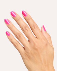 Hand displays a glossy hot pink shimmer manicure using OPI Power up Pink Nail Lacquer on almond-shaped nails against a clean white background.