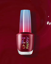 OPI RapiDry nail polish in Skip a Beet, a deep beet-red shade for fall nail colors, displayed in a glass bottle with an iridescent cap on a glossy burgundy background.