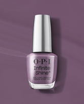 OPI Infinite Shine Reign or Shine gel-like lacquer bottle stands on a mauve purple background, showcasing a soft dusty lavender shade for fall nail colors.