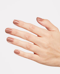 Hand displays glossy warm mauve-brown Rooting For Hue OPI Nature Strong Vegan Nail Lacquer on short rounded nails against a clean white background, a trending neutral manicure shade.