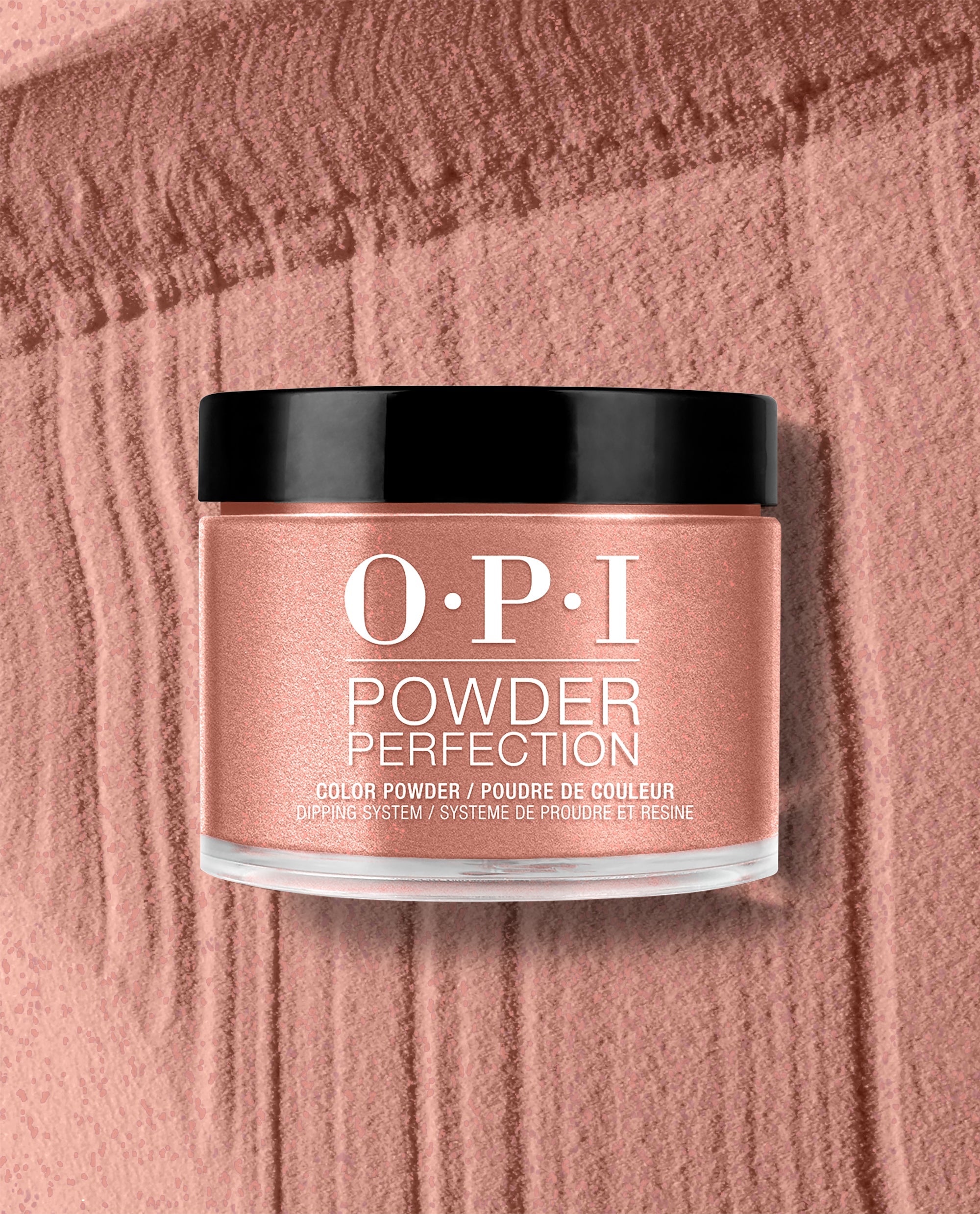 OPI Powder Perfection Route Beer Float dipping powder jar sits on a textured rosy bronze powder swatch, showcasing a shimmering fall nail color with black cap and clear base.