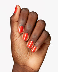 Hand displays glossy, shimmering orange nails painted with OPI Infinite Shine in Shock Em Orange, a trending bright manicure shade on a clean white background.