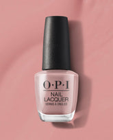 OPI nail polish bottle of Somewhere Over the Rainbow Mountains nail lacquer standing upright, showcasing its soft rosy nude shade against a matching blush pink background for a clean, modern product close-up.
