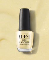 OPI Buttafly yellow Nail Lacquer bottle stands upright with a black cap on a pale yellow glitter background, showcasing the soft pastel polish shade.