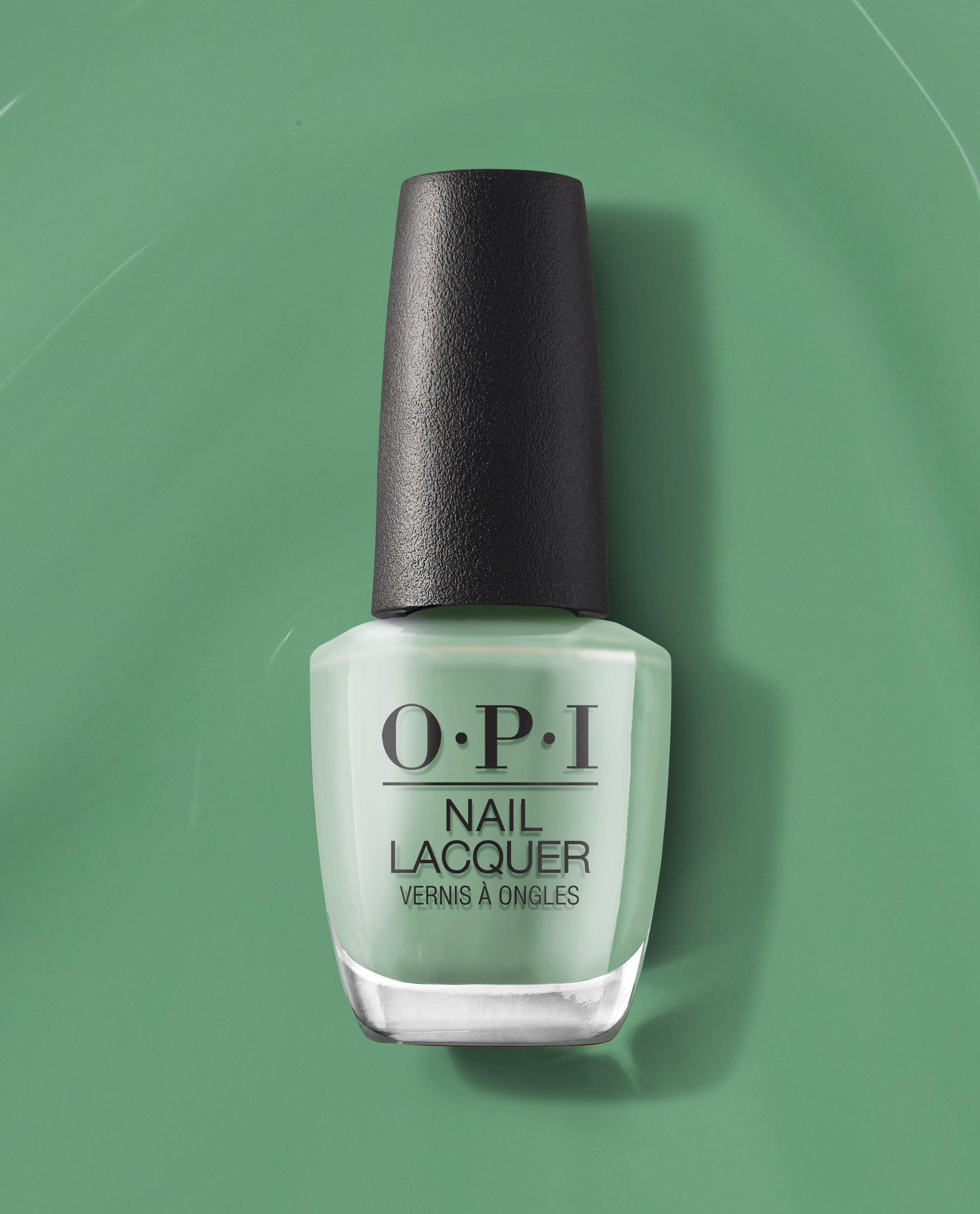 OPI $elf Made Nail Lacquer bottle standing upright, showcasing a pastel mint green shade of green nail polish with a black textured cap, set against a matching green backdrop—a fresh, modern pick for spring nail colors from OPI.