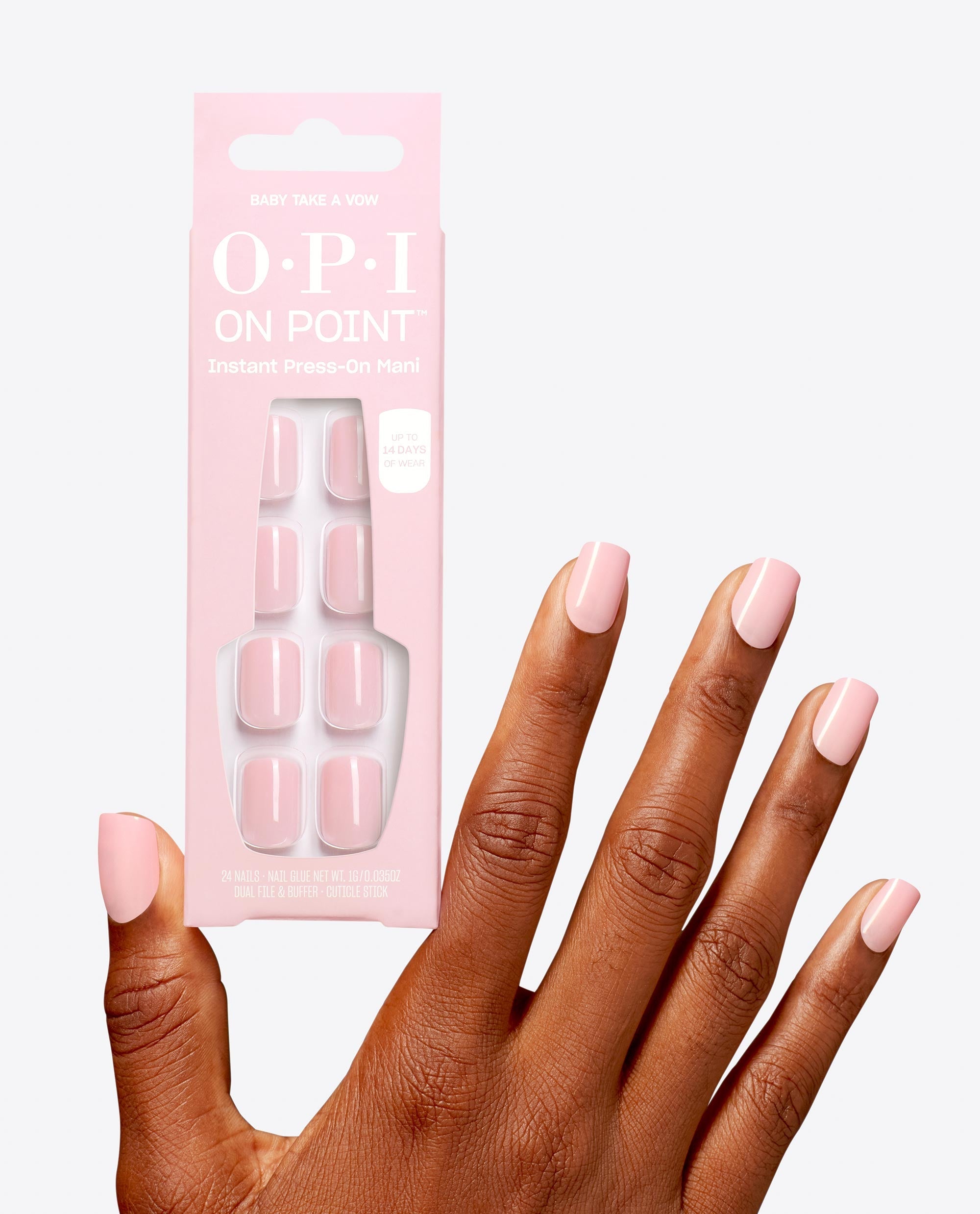 Hand with glossy pale pink manicure holds OPI Baby, Take a Vow On Point instant press-on mani, showing soft pink square nails in the OPI nail polish gift set packaging against a clean white background.