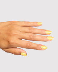 Hand modeling OPI Infinite Shine Slay Hello to Yellow, a glossy pale yellow nail polish with subtle shimmer on almond-shaped nails against a light gray background.