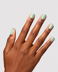 Manicured hand showcases Teals Familiar Infinite Shine by OPI, a pastel mint-teal green nail polish with subtle shimmer on short rounded nails against a light gray background, a fresh pick for spring nail colors.