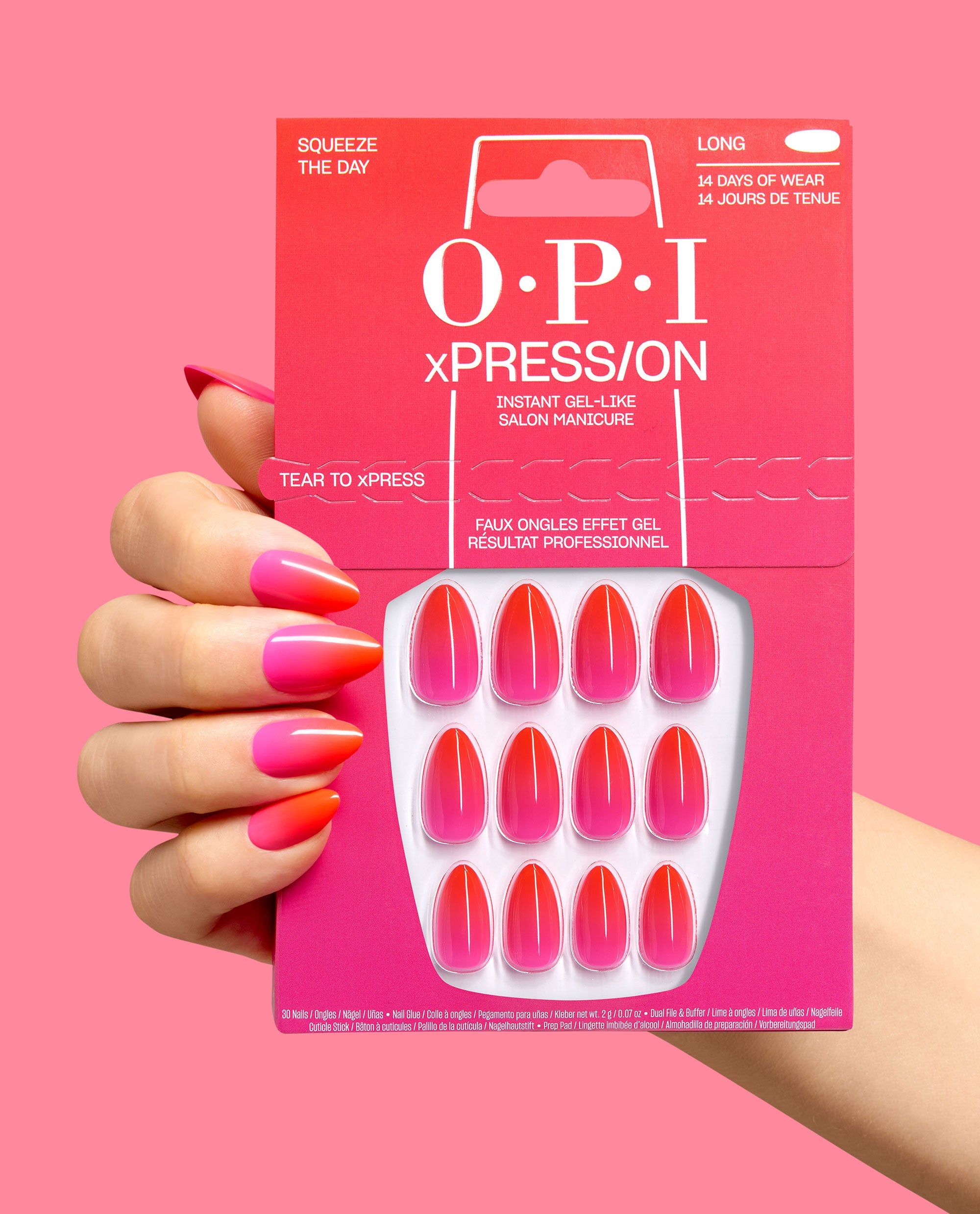 Hand with glossy pink-to-orange ombré almond nails holds the trending OPI xPRESS/ON Squeeze the Day press-on nail kit, showing matching gel-like nails in bright pink packaging.