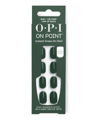 OPI On Point Suzi - The First Lady of Nails press-on manicure set displays glossy deep green artificial nails in a dark green box, with 24 nails, glue, file, buffer, cuticle stick, and prep pad.